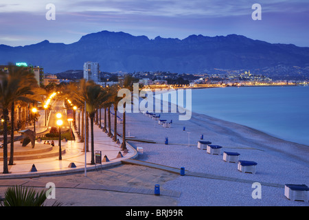 Panoramic view of the illuminated beach of Albir at dusk, with the old town of Altea in the background. Promenade of the stars. Stock Photo