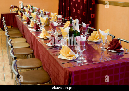 laid table with tableware and dishes for banquet in bordeaux and yellow tones, shallow DOF Stock Photo