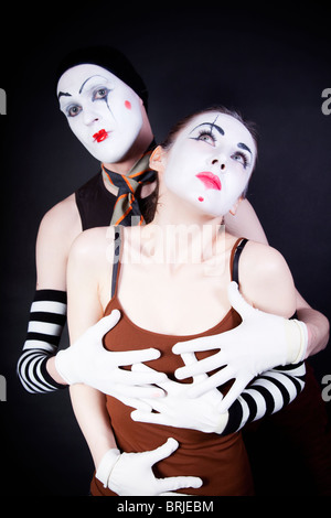 Couple embracing mimes on a black background Stock Photo