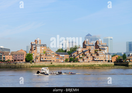 A Tugboat on the Thames passing Canary Wharf and Riverside Apartments on The Isle of Dogs, Docklands, London, England, UK, Stock Photo