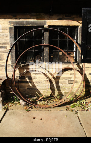 Shibden Hall Halifax Yorkshire symetrical arrangement of Cart wheel rims Stock Photo