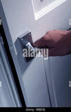 Male hand turning an internal door handle Stock Photo