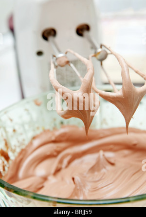 cake mix with white blender dripping batter into the bowl Stock Photo
