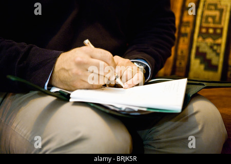 Man writing on note pad, cropped Stock Photo