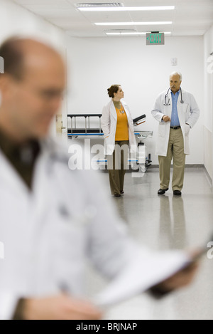 Doctors walking down hospital corridor Stock Photo