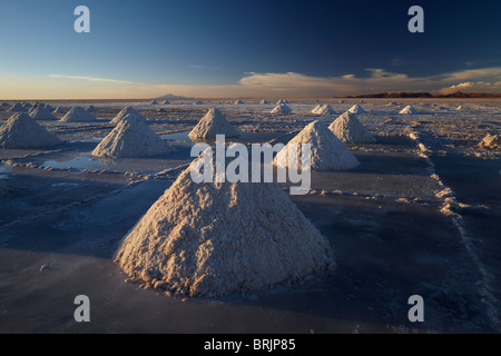 piles of salt on the Salar de Uyini at dusk, Bolivia Stock Photo