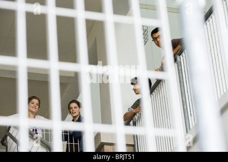 High school students leaning against stairwell railing, low angle view