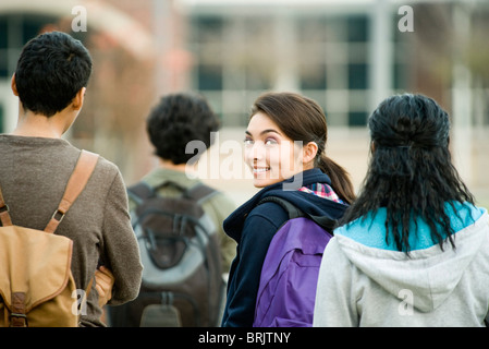 Teenage girl walking with classmates Stock Photo