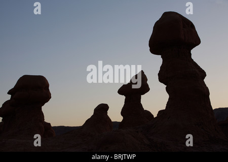 Hoodoos are individual, small rock formations, silhouetting the sky in Goblin Valley State Park, Utah. Stock Photo