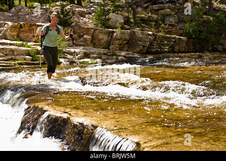 A woman wades across the Provo River in Utah's Uinta Mountains.