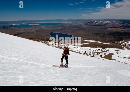 During his last ski tour for the season, a young man skins up the mountain with Mono Lake in the background, in June Lake, Calif Stock Photo