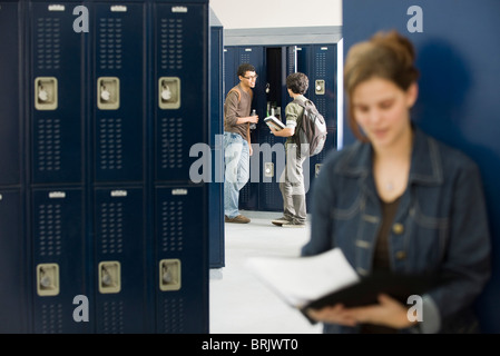 High school students chatting by lockers Stock Photo