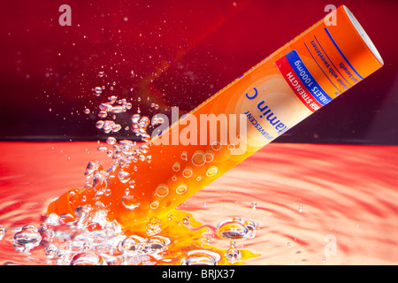 A tube of effervescent vitamin C tablets under water and creating fizz and bubbles Stock Photo