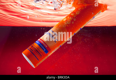 A tube of effervescent vitamin C tablets under water and creating fizz and bubbles Stock Photo