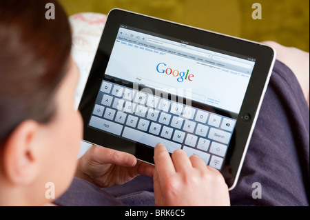 Woman searching internet using Google search engine on an iPad tablet computer Stock Photo
