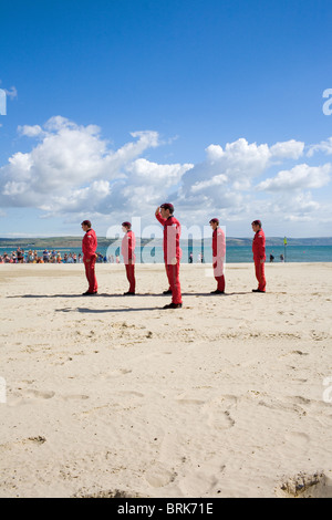 The Red Devils parachute display team stand to attention after a drop onto Weymouth beach. Stock Photo
