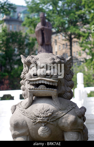 Chinese Lion with statue of Confusious in background Chinese cultural garden Cleveland Ohio Stock Photo