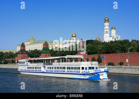 A sightseeing boat cruising along the Moskva River past the Kremlin (1482-1495) on a beautiful summer day in Moscow, Russia Stock Photo