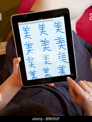Woman practicing to write Chinese characters on an iPad tablet computer Stock Photo