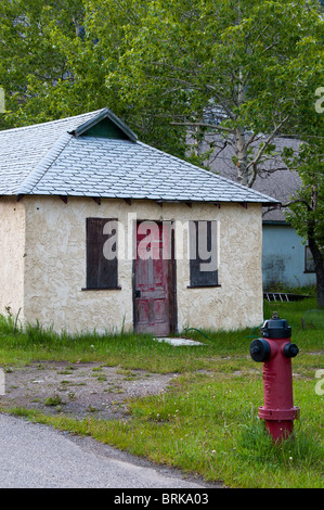 Faded red door on closed building, Waterton Park, Alberta, Canada. Stock Photo