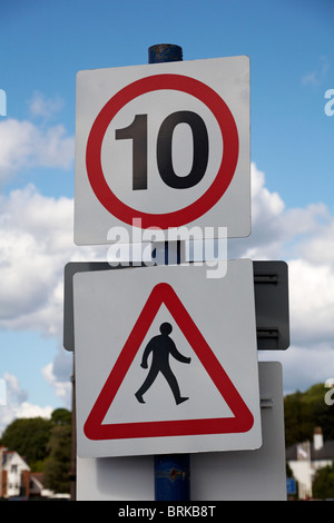 10 mph speed limit sign and pedestrians walking sign pedestrians crossing road sign, pedestrian crossing sign - UK Stock Photo