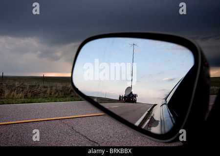 Shot through a rearview mirror, a Doppler on Wheels truck scans a supercellular thunderstorm in rural Wyoming, May 21, 2010. Stock Photo