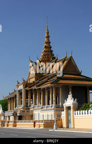 A Buddhist monk is walking in front of a building on the grounds of The Royal Palace in Phnom Penh, Cambodia. Stock Photo