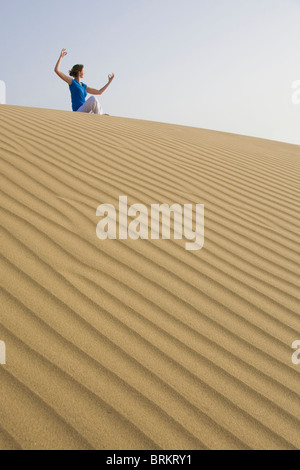 Woman doing yoga in the Maspalomas sand dunes Stock Photo