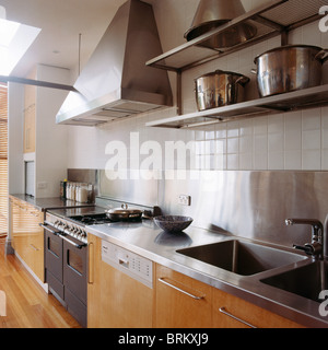 Modern stainless steel kitchen shelves with stacks of plates and ...
