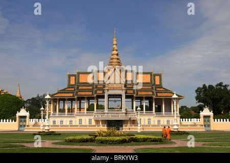 Two Buddhist monks are walking in front of a building on the grounds of The Royal Palace in Phnom Penh, Cambodia. Stock Photo