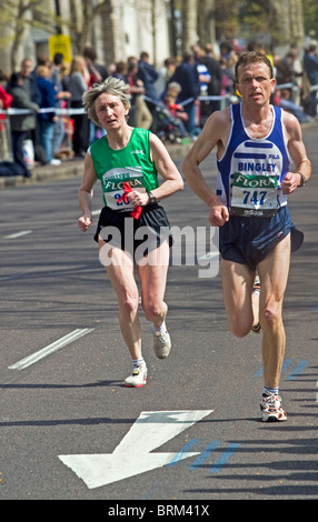 male and female competitive runners taking part in the London Marathon. Stock Photo