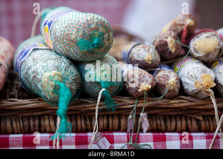 A display of locally produced salamis for sale in a local market stall in San Gimignano, Tuscany Italy Stock Photo