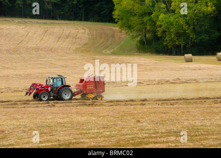 Farm tractor rolling hay bales in a Civil War battlefield, Chickamauga, GA Stock Photo