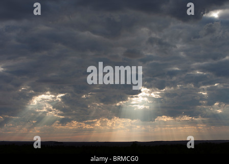 Sun shining through dark clouds , Finland Stock Photo