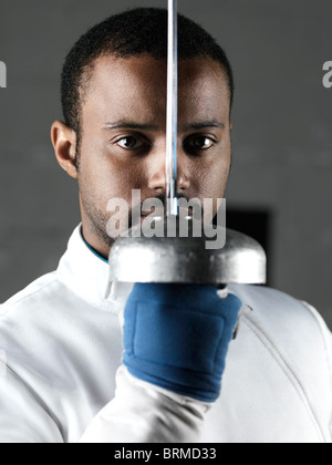 Portrait of a fencer holding an épée in front of his face Stock Photo