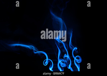 deep blue ethereal smoke trickling upward in spirals Stock Photo