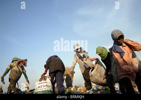 Workers are walking over trash while searching through garbage at The Stung Meanchey Landfill in Phnom Penh, Cambodia. Stock Photo