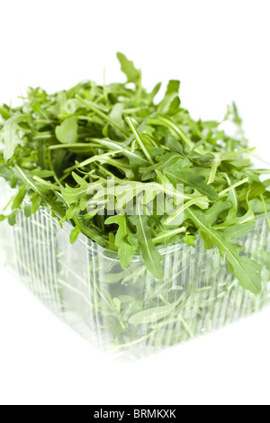 Rocket leaves In A Plastic Container Isolated On White Stock Photo