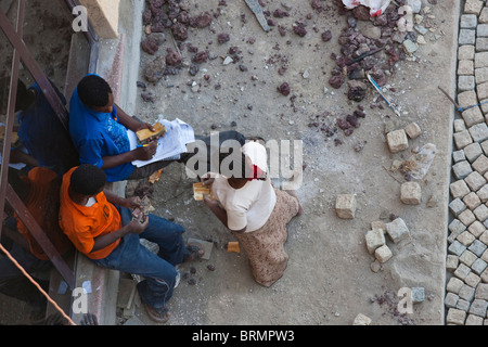 Overhead view of supervisors paying a woman working on a construction site Stock Photo