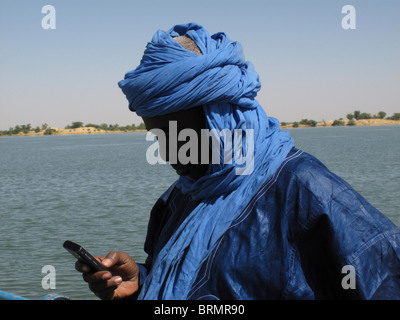 Tuareg man dressed in traditional blue robes using a cell phone Stock Photo