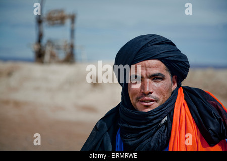Portrait of a Berber man standing in front of an old well at a place of rest. Stock Photo