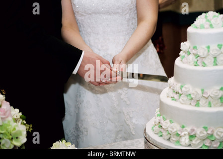 man and woman cutting their wedding cake Stock Photo
