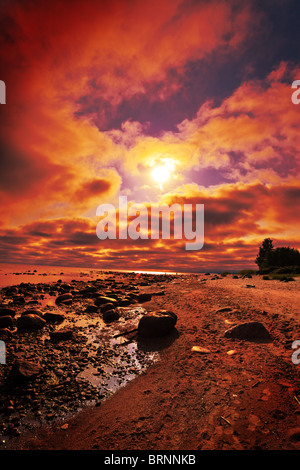 crimson sunset on a beach Stock Photo