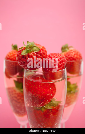 Champagne flutes containing champagne and strawberries, close-up Stock Photo