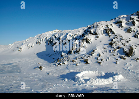 The remains of a snow shelter near Sprinkling Tarn in the English Lake District. Stock Photo