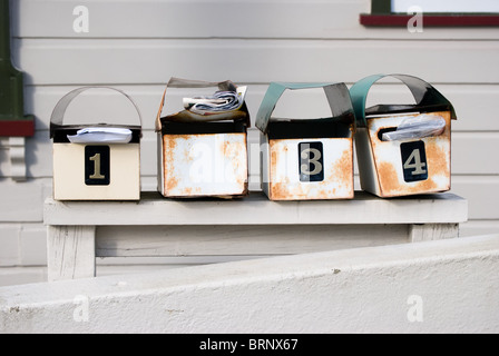 Mail boxes with post against wooden house. Stock Photo
