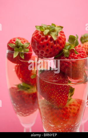 Champagne flutes containing champagne and strawberries, close-up Stock Photo