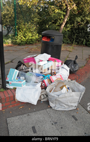 A pile of rubbish beside an overflowing bin in Hounslow, Middx, UK. Stock Photo
