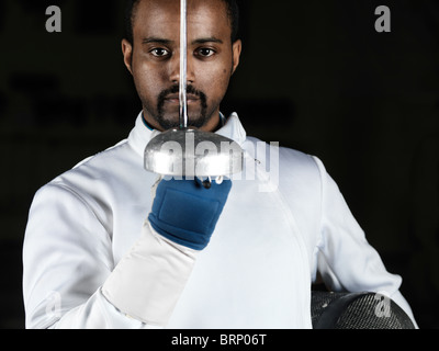 Portrait of a fencer holding an epee in front of his face Stock Photo