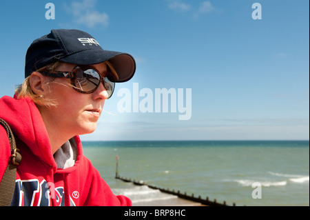 Outdoor portrait of a woman looking thoughtful at the seaside in England. Stock Photo